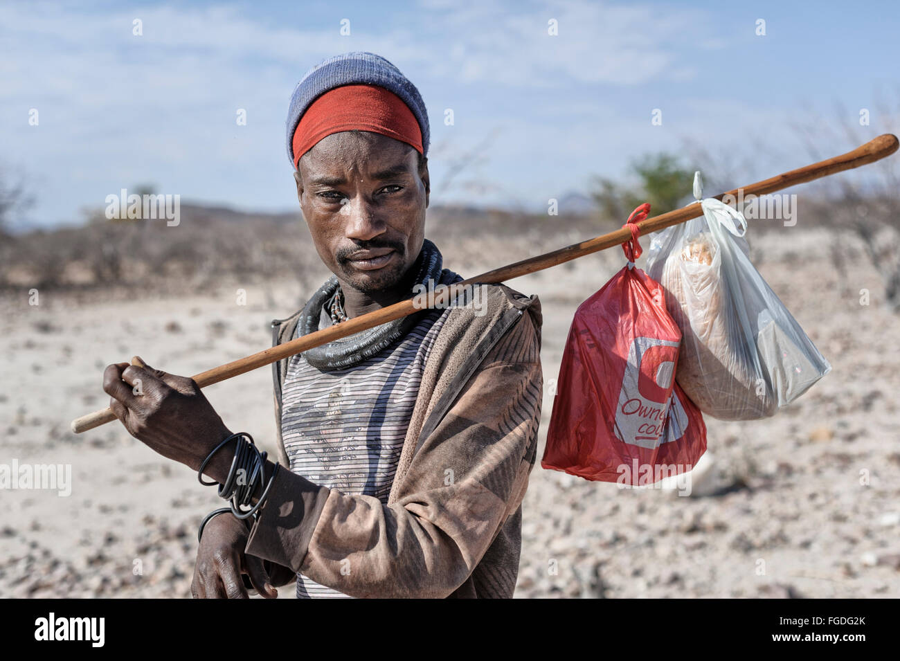 Homme Himba portant sa choses sur un bâton. Banque D'Images