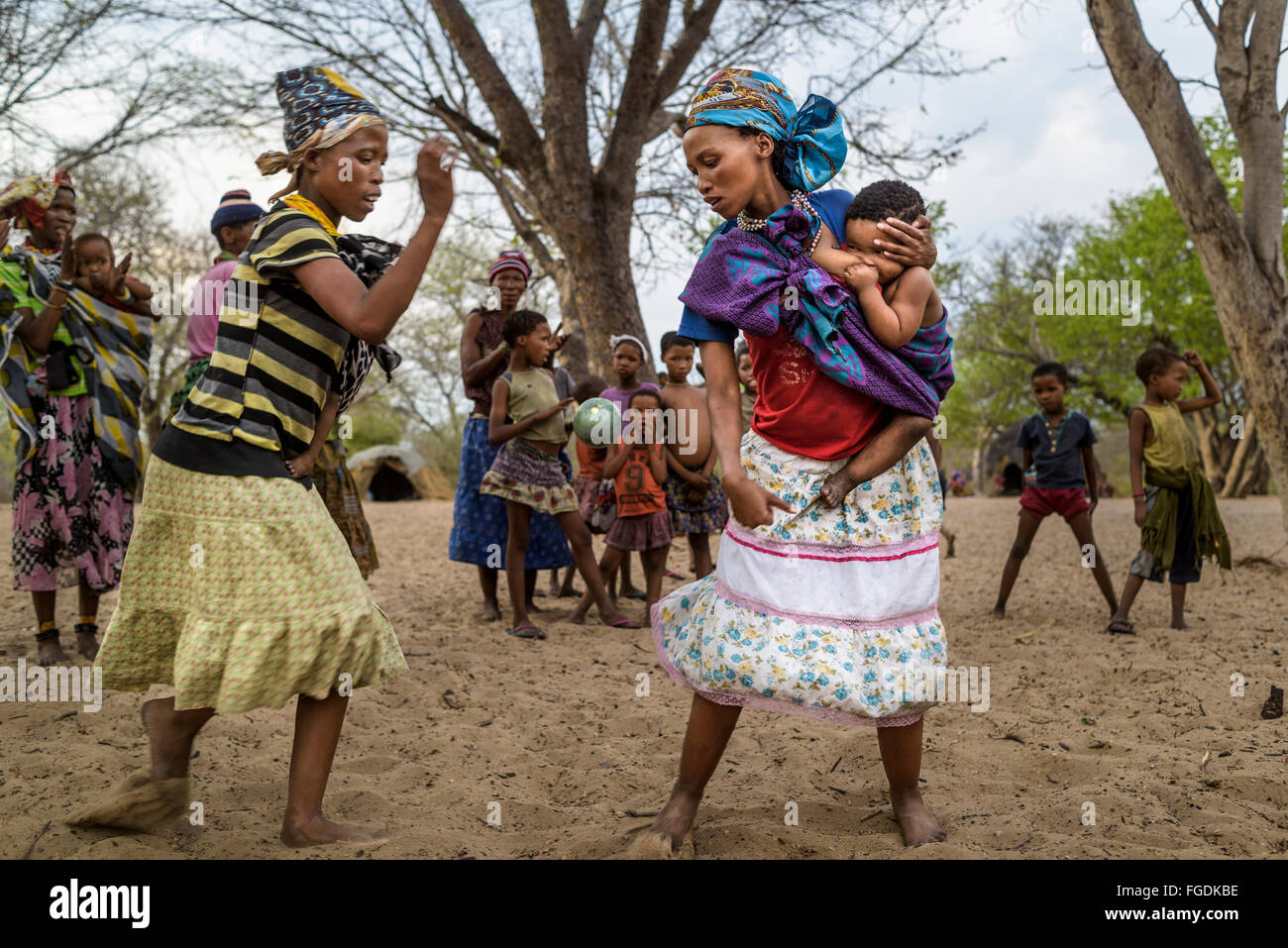 Groupe de personnes de la tribu San joue un jeu avec un fruit appelé 'Monkey orange' dans un village éloigné du désert du Kalahari. Banque D'Images