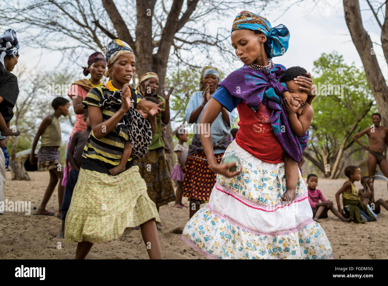 Groupe de personnes de la tribu San joue un jeu avec un fruit appelé 'Monkey orange' dans un village éloigné du désert du Kalahari. Banque D'Images