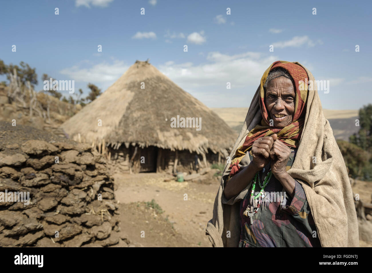 Portrait d'une vieille femme devant sa hutte de terre dans les montagnes. Banque D'Images