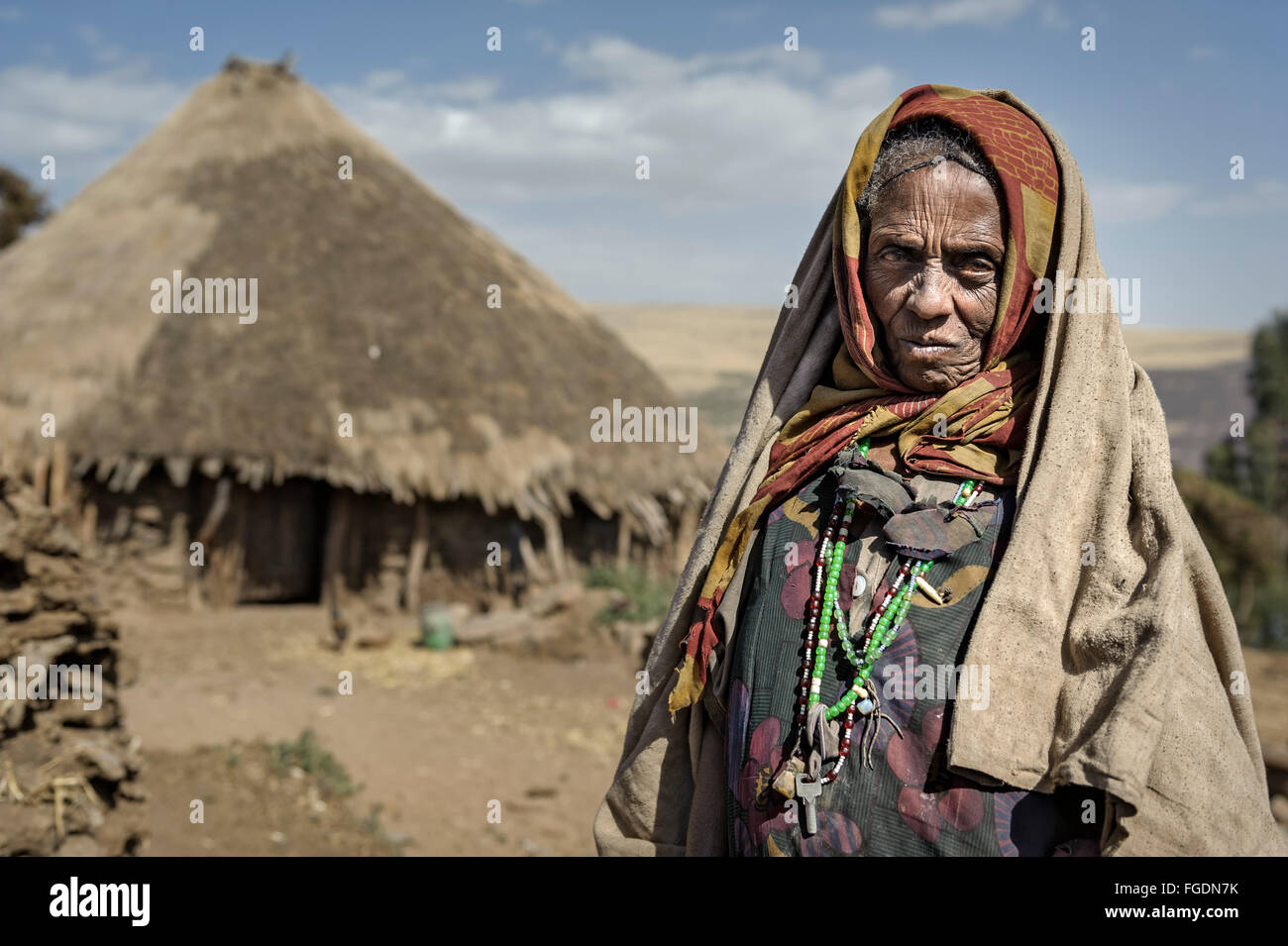 Portrait d'une vieille femme devant sa hutte de terre dans les montagnes. Banque D'Images