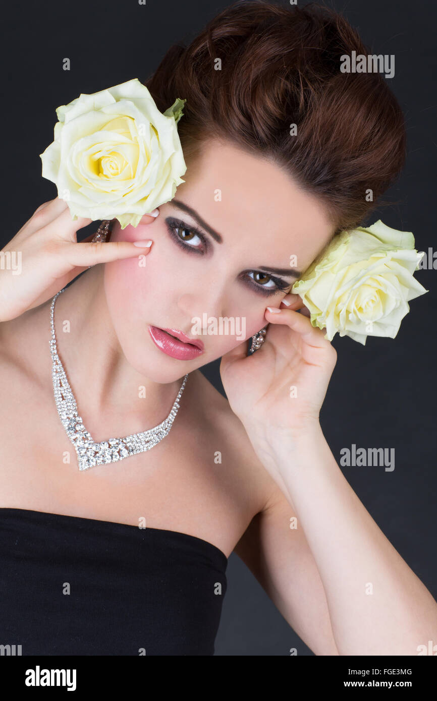 Jeune femme tenant deux roses jaunes latéralement nex Banque D'Images
