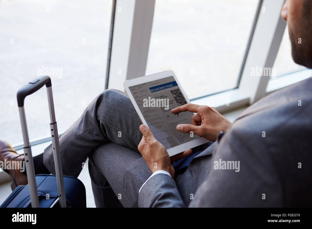 Businessman Viewing Embarquement In Airport Lounge Banque D'Images