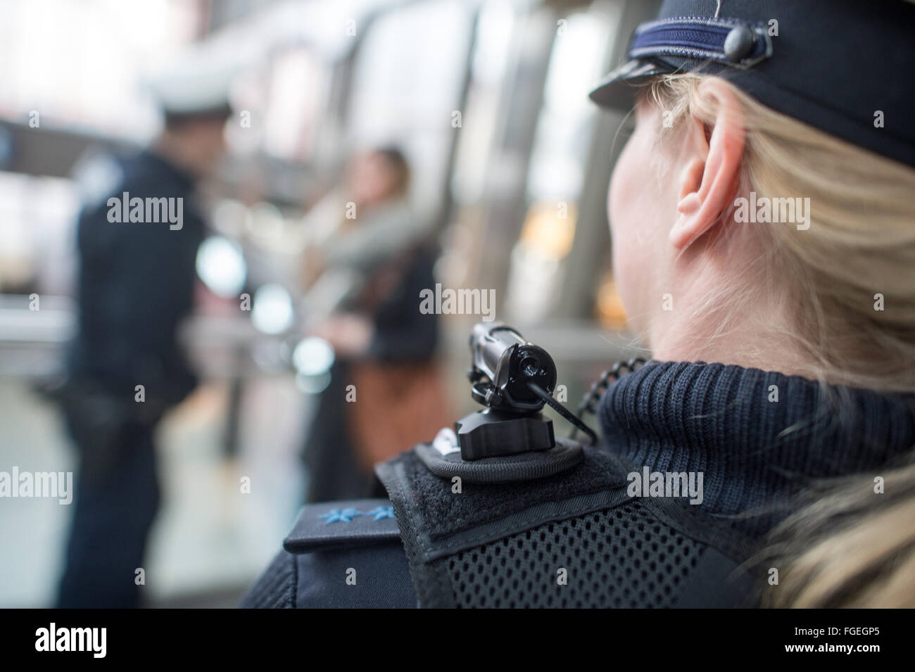 Munich, Allemagne. Feb 19, 2016. Julia S., une policière de la Police fédérale portant un corps mobile appareil photo et un gilet spécial indiquant la surveillance vidéo à la gare centrale de Munich, Allemagne, 19 février 2016. En date d'aujourd'hui, Police fédérale dans les tests de Munich caméras miniatures qui sont rattachées à ces vestes et sera utilisé pendant des situations spécifiques afin d'effrayer des attaquants. PHOTO : MATTHIAS BALK/dpa/Alamy Live News Banque D'Images