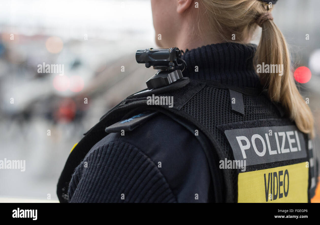 Munich, Allemagne. Feb 19, 2016. Julia S., une policière de la Police fédérale portant un corps mobile appareil photo et un gilet spécial indiquant la surveillance vidéo à la gare centrale de Munich, Allemagne, 19 février 2016. En date d'aujourd'hui, Police fédérale dans les tests de Munich caméras miniatures qui sont rattachées à ces vestes et sera utilisé pendant des situations spécifiques afin d'effrayer des attaquants. PHOTO : MATTHIAS BALK/dpa/Alamy Live News Banque D'Images