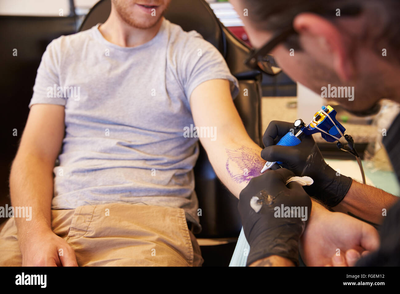 Close Up of Man Sitting in Chair ayant Tattoo Banque D'Images