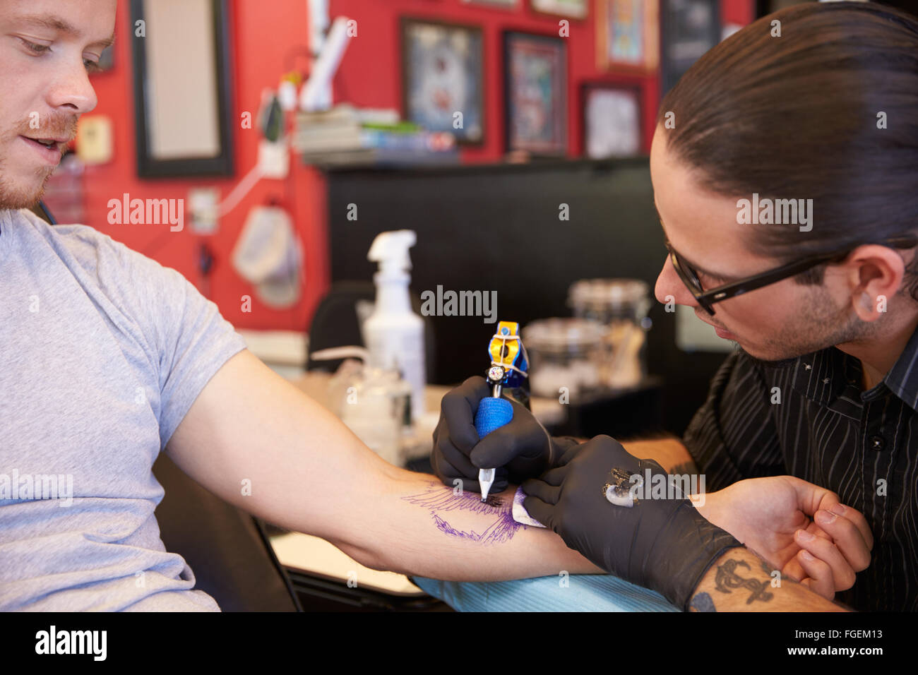 Le travail sur le design de l'artiste de tatouage pour les clients masculins Banque D'Images
