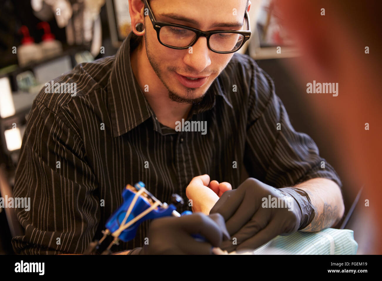 Le travail sur le design de l'artiste de tatouage pour les clients masculins Banque D'Images