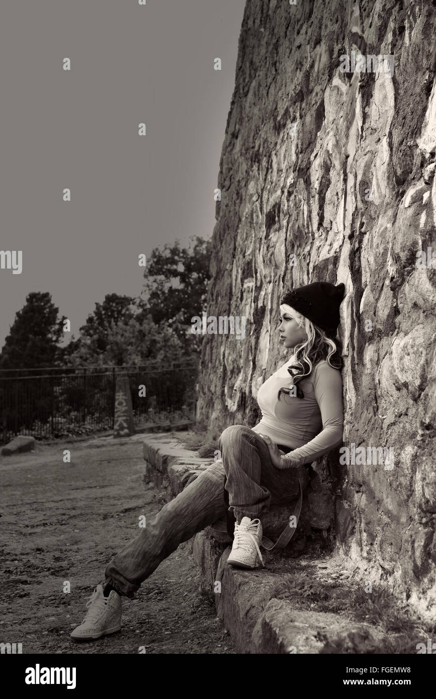 Modèle féminin en milieu urbain murs graffiti portait un jean et haut blanc Banque D'Images