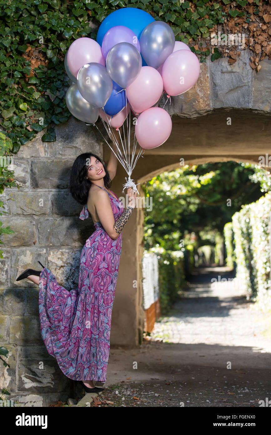Jeune femme avec de long dress posing with colourful b Banque D'Images