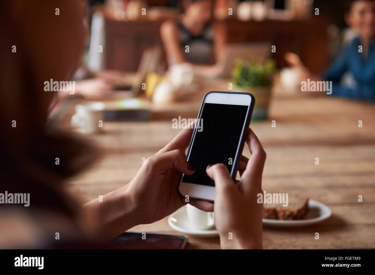Close Up of Woman Using Mobile Phone In cafe Banque D'Images