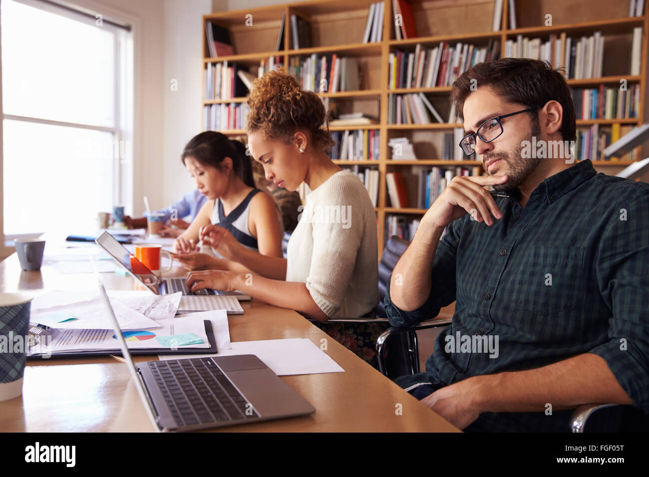 Businessman Using Laptop At Desk In Office Occupé Banque D'Images