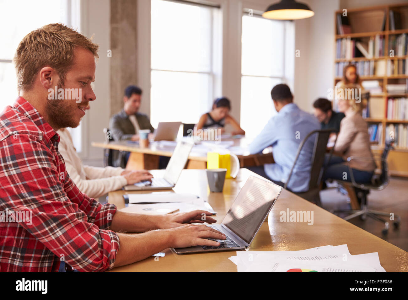 Businessman Using Laptop At Desk In Office Occupé Banque D'Images