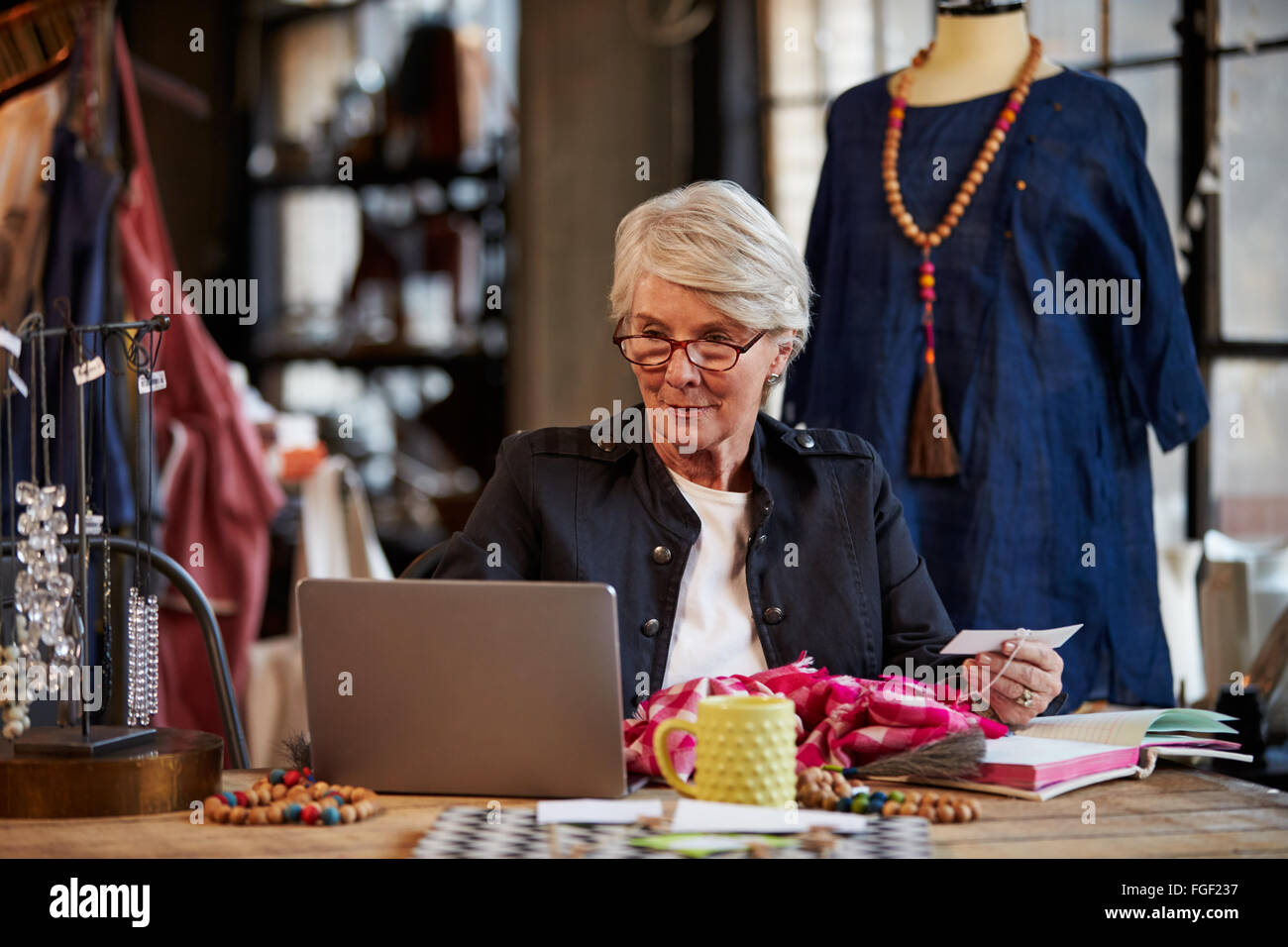 Femme Fashion Designer Working at Laptop In Studio Banque D'Images