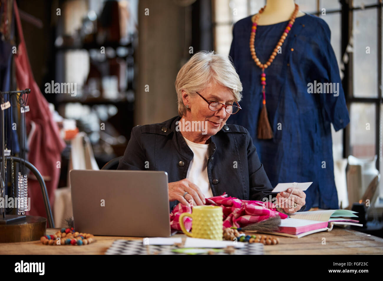 Femme Fashion Designer Working at Laptop In Studio Banque D'Images