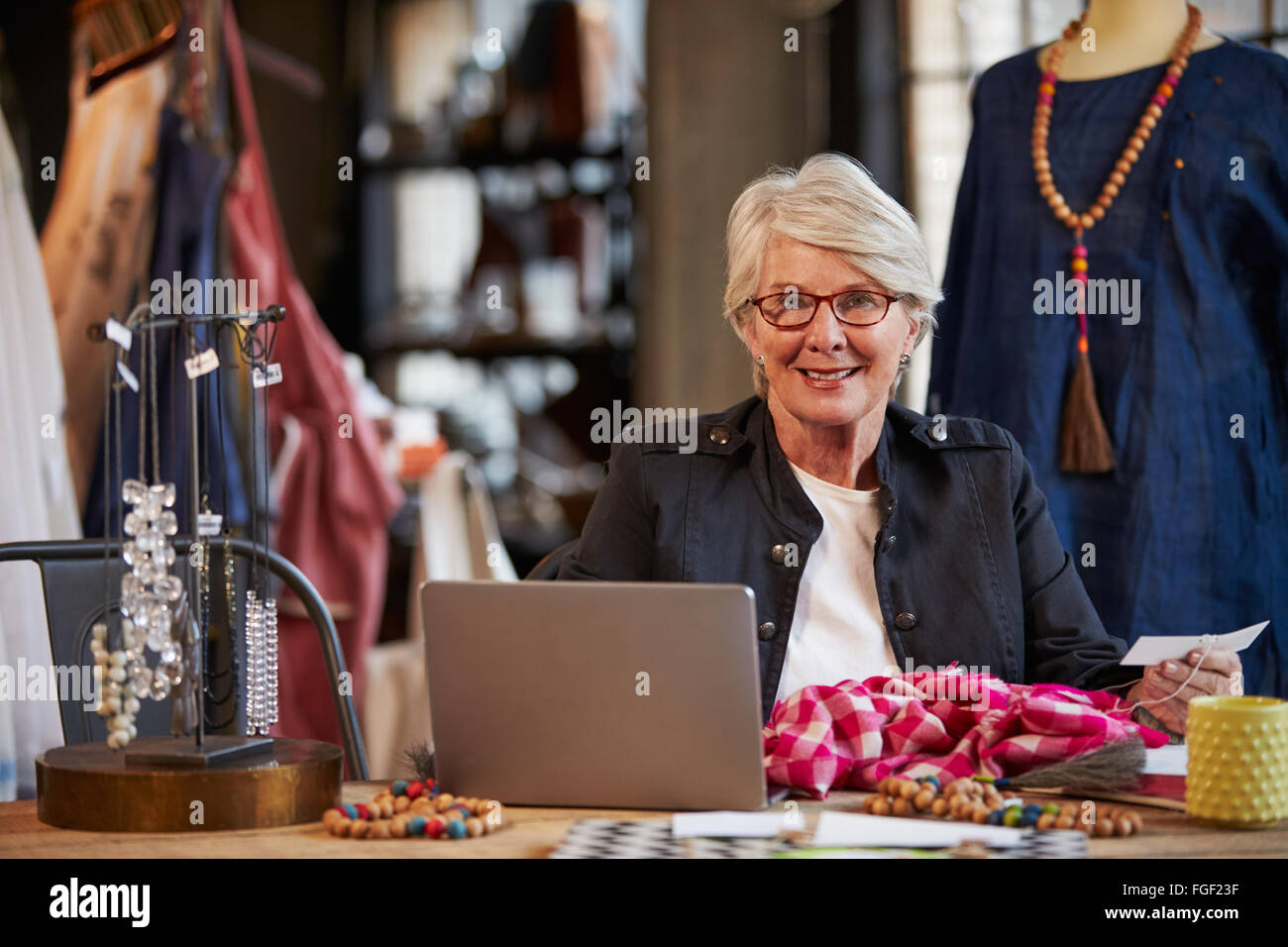 Femme Fashion Designer Working at Laptop In Studio Banque D'Images