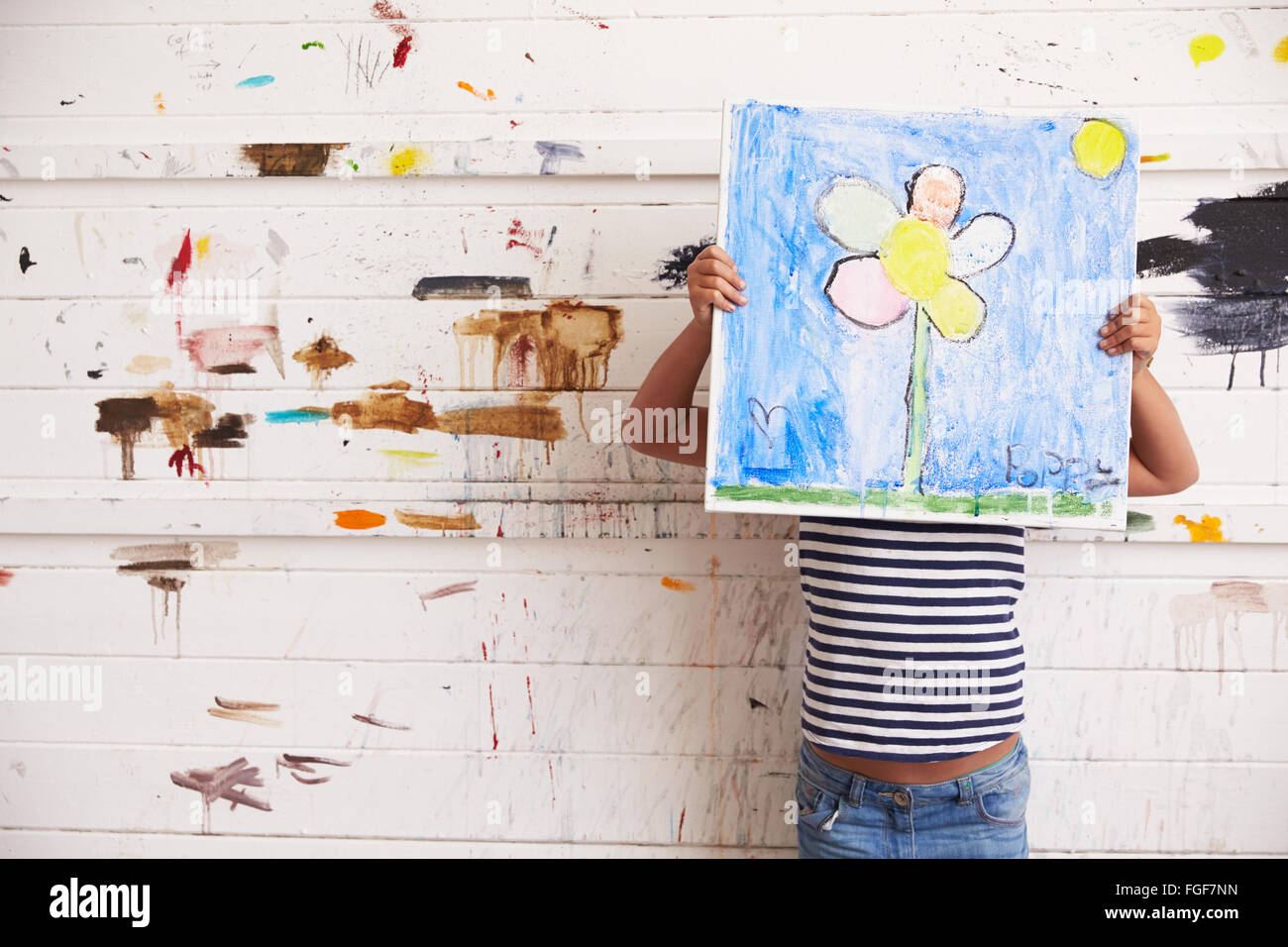 Girl Holding contre la Peinture Peinture murale couverte en Studio Banque D'Images