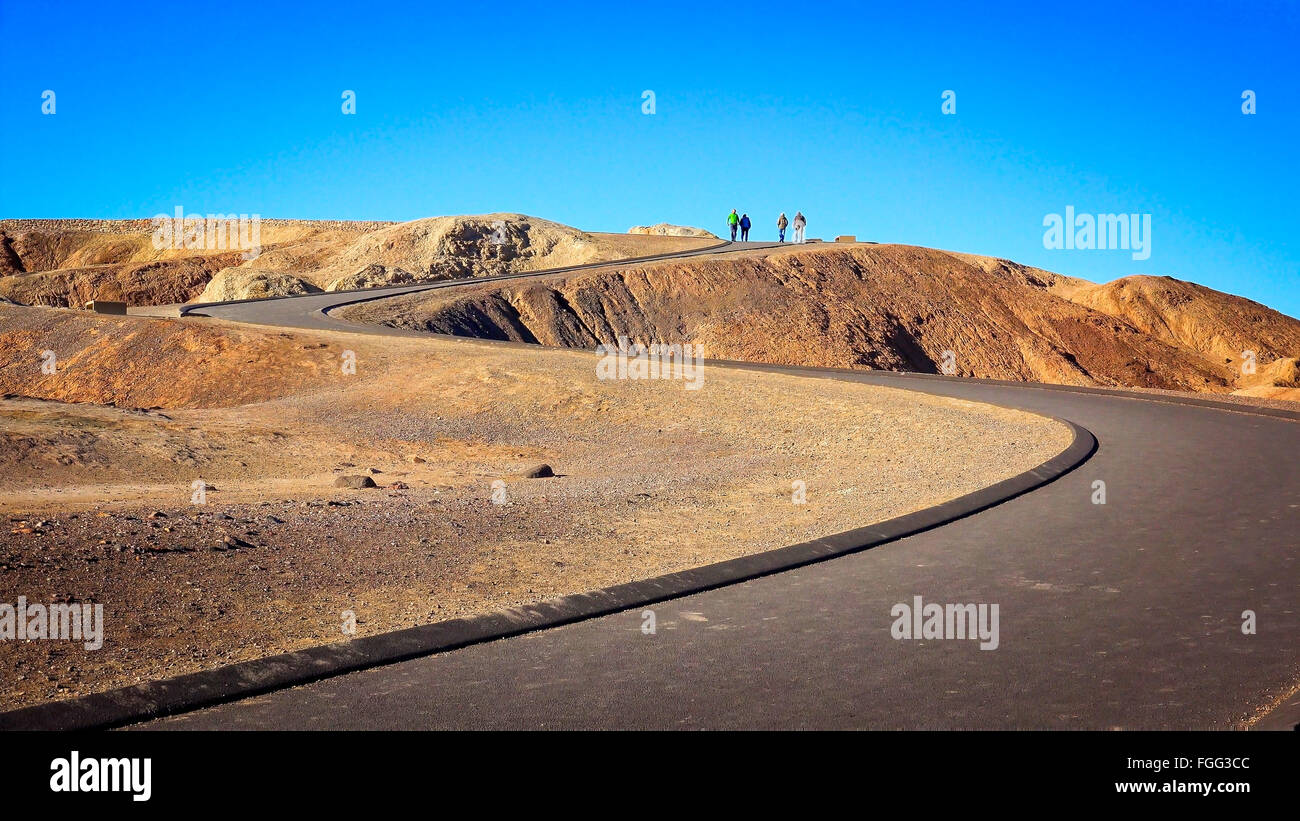 Les visiteurs au sommet d'un sentier sinueux menant à Zabriskie Point dans Death Valley National Park Banque D'Images