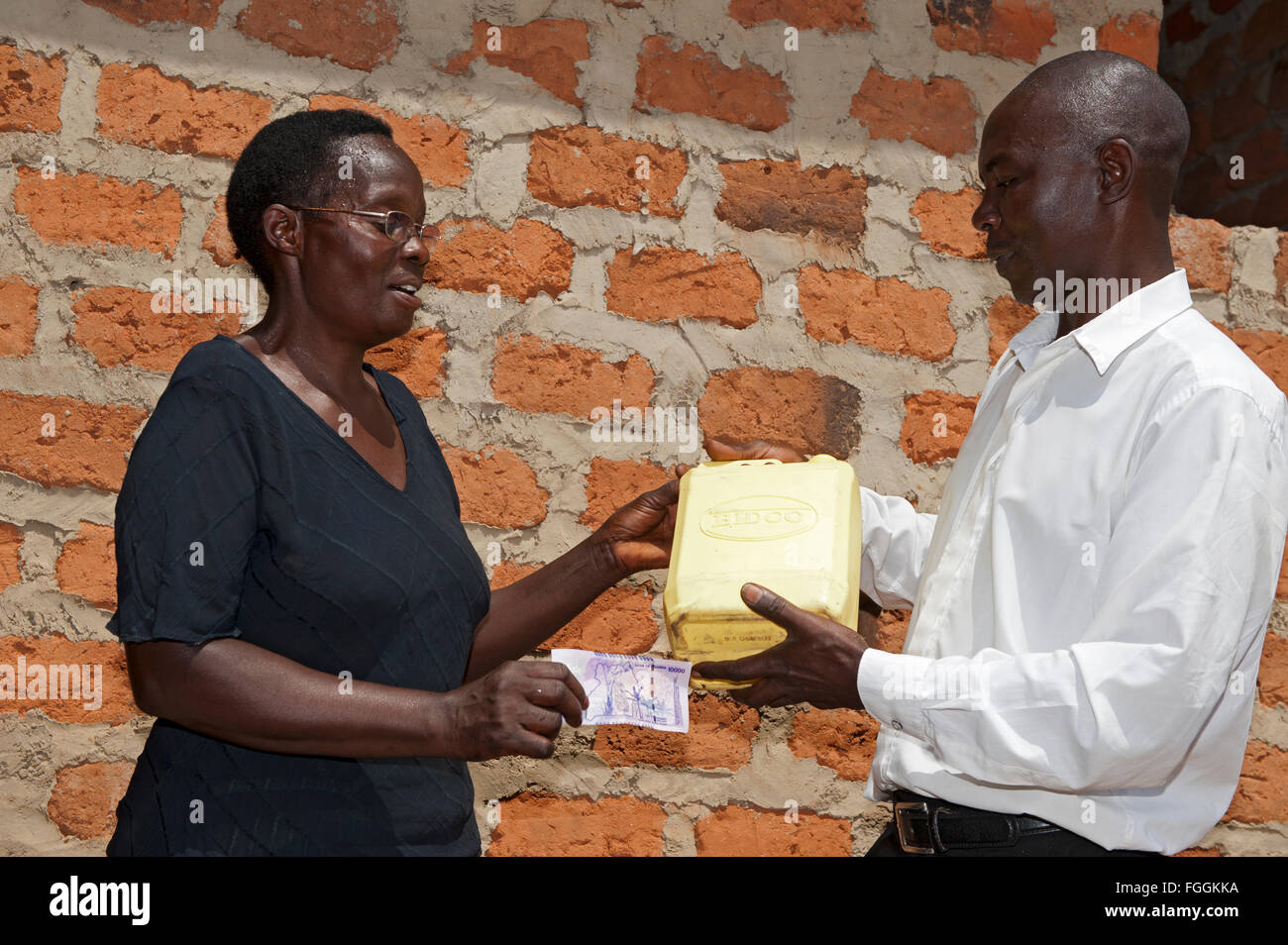 Femme ougandaise vente du lait à la prospérité à la client. Banque D'Images