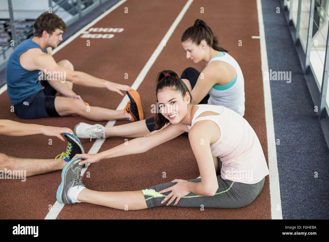Quatre hommes et femmes s'étendant d'athlétisme Banque D'Images