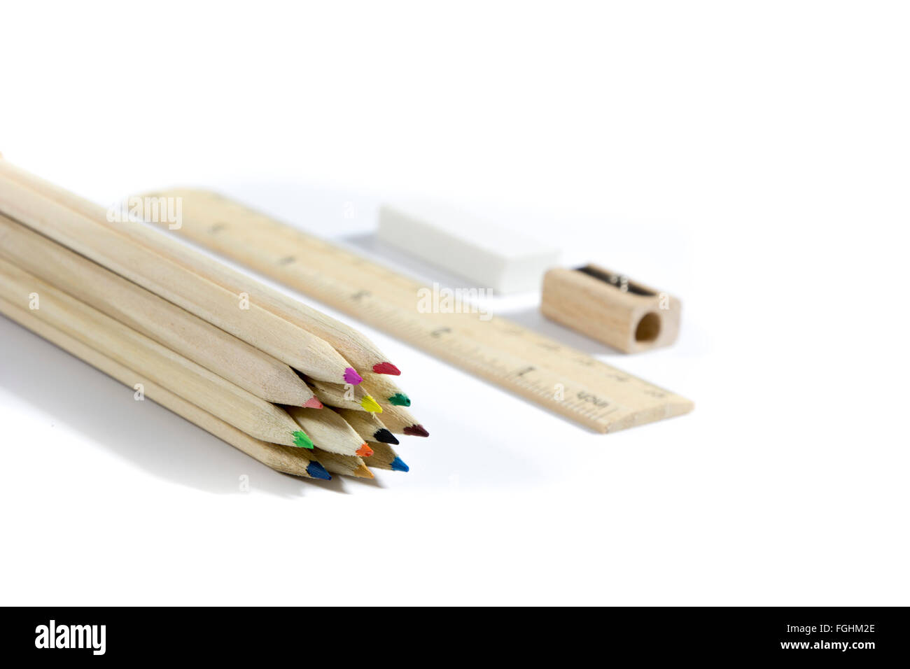 Crayon, gomme, taille-crayon, règle en bois sur fond blanc Banque D'Images