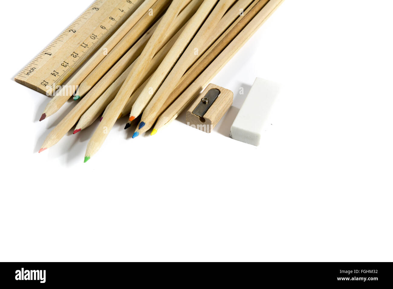 Crayon, gomme, taille-crayon, règle en bois sur fond blanc Banque D'Images