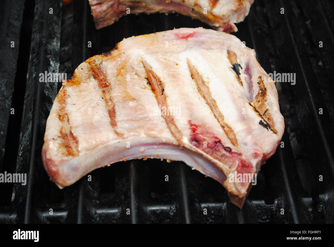 Côtelette de porc maigre cuisson sur une grille d'été Banque D'Images