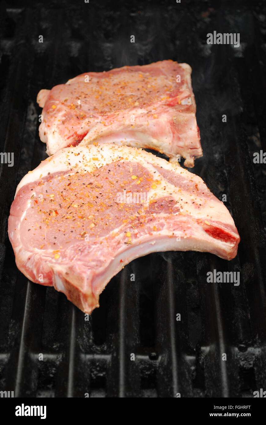 Côtelettes de porc maigre sur une grille de cuisson Banque D'Images
