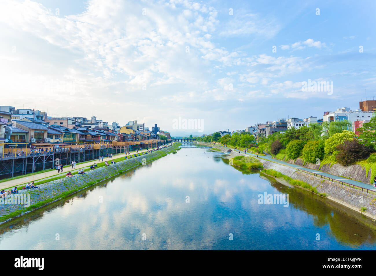 Les gens au repos et restaurants bordent les rives de la rivière Kamo sur un ciel bleu jour dans le centre de Kyoto. L'horizontale Banque D'Images