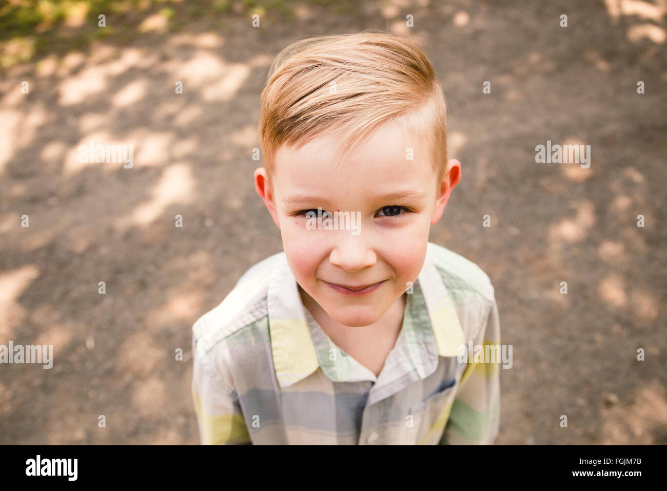 Jeune garçon à l'extérieur dans un style de portrait en lumière naturelle. Banque D'Images