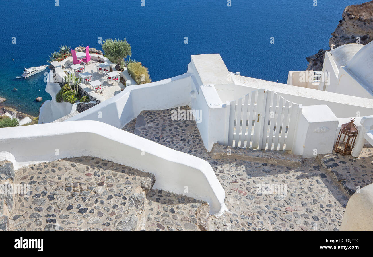 Santorin - Le restaurant mariage à dîner romantique à Oia (Ia) et le yacht sous des falaises à l'arrière-plan. Banque D'Images