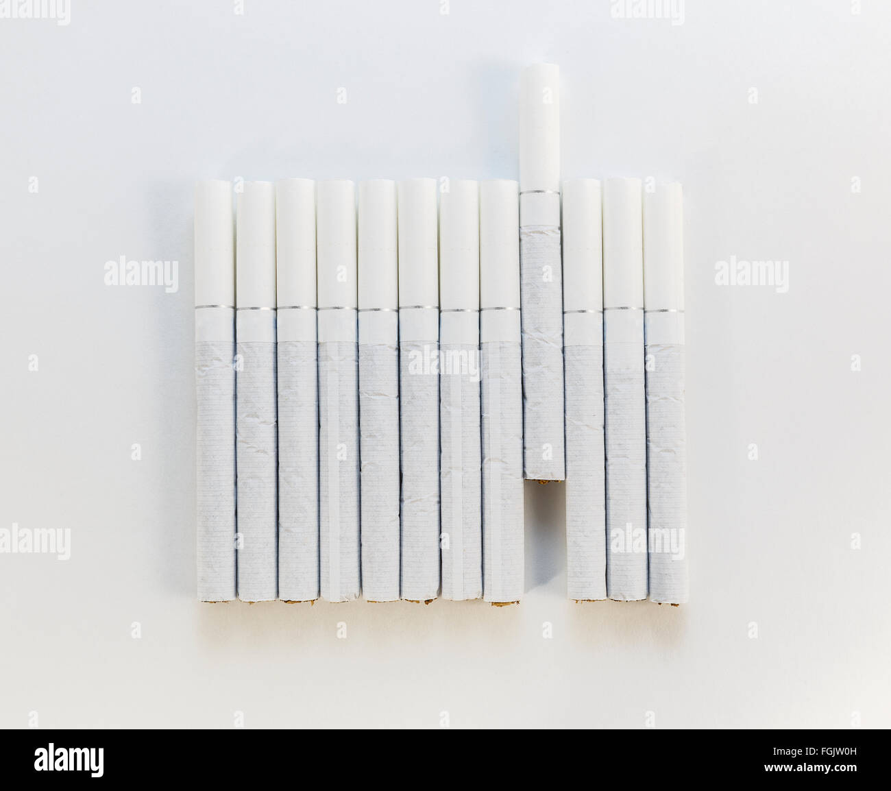 Cigarette avec un filtre blanc disposés dans une rangée sur un fond blanc  Photo Stock - Alamy