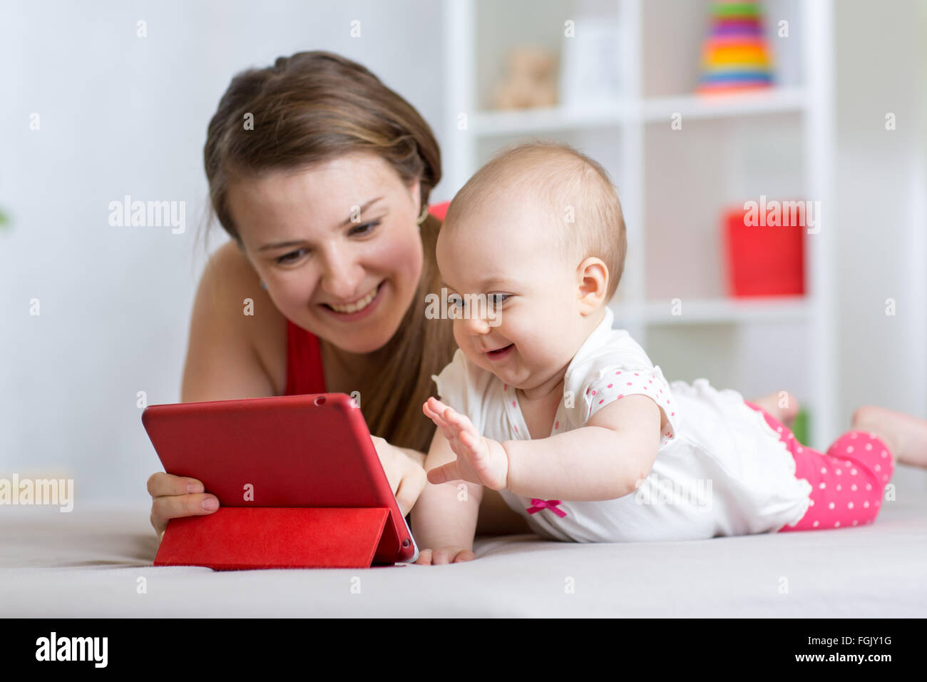 Famille - la mère et le bébé avec tablette sur marbre à la maison. Femme et enfant girl relaxing at tablet computer. Banque D'Images