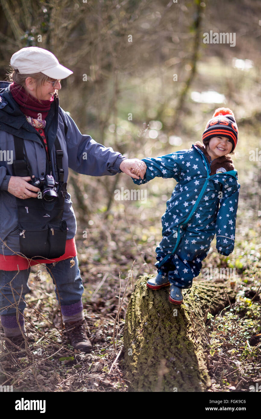 Mixed Race trois ans profiter de jouer en hiver bois avec sa grand-mère. Banque D'Images