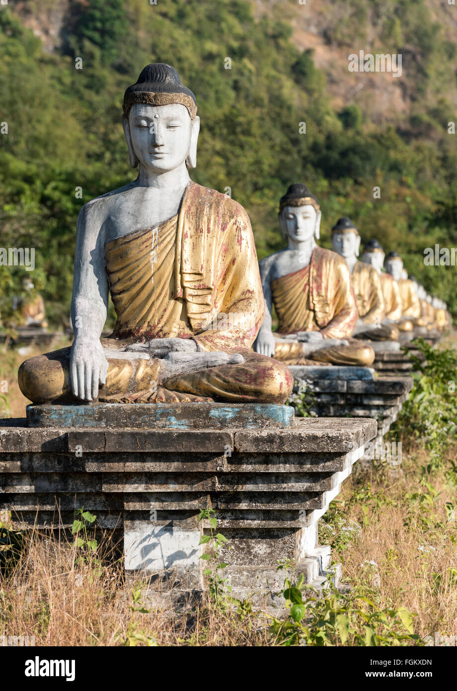 Les statues de Bouddha sont alignées en rangées sous Mt Zwegabin, Hpa-an, l'État de Kayin (Karen), la Birmanie Banque D'Images