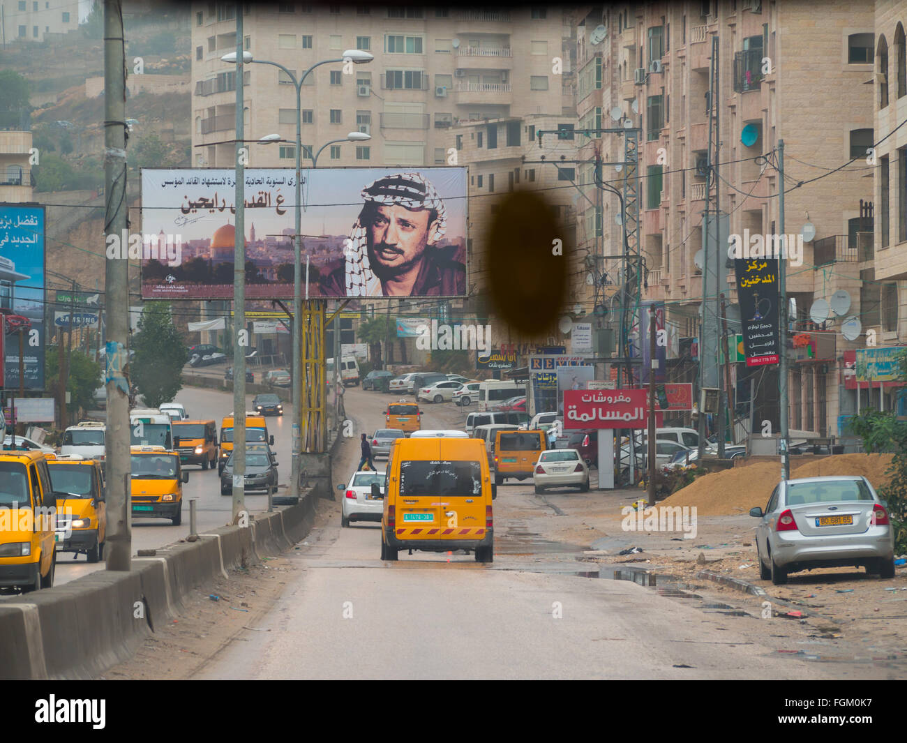 Rue de Ramallah vu de l'intérieur de la voiture avec Arafat dans l'extrême de l'affiche Banque D'Images