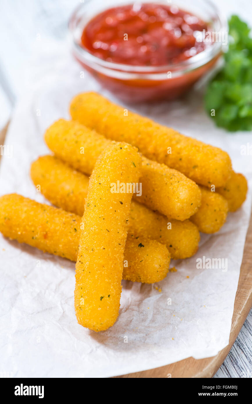 Bâtonnets de mozzarella frits avec une trempette maison sur fond de bois (selective focus) Banque D'Images