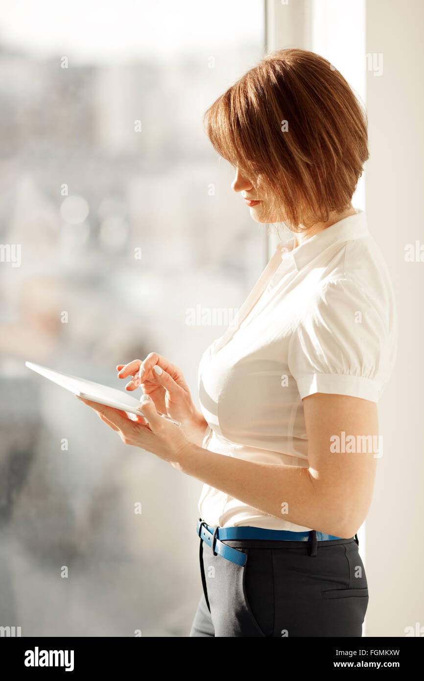 Vue latérale sur la femme au travail sur tablet Banque D'Images