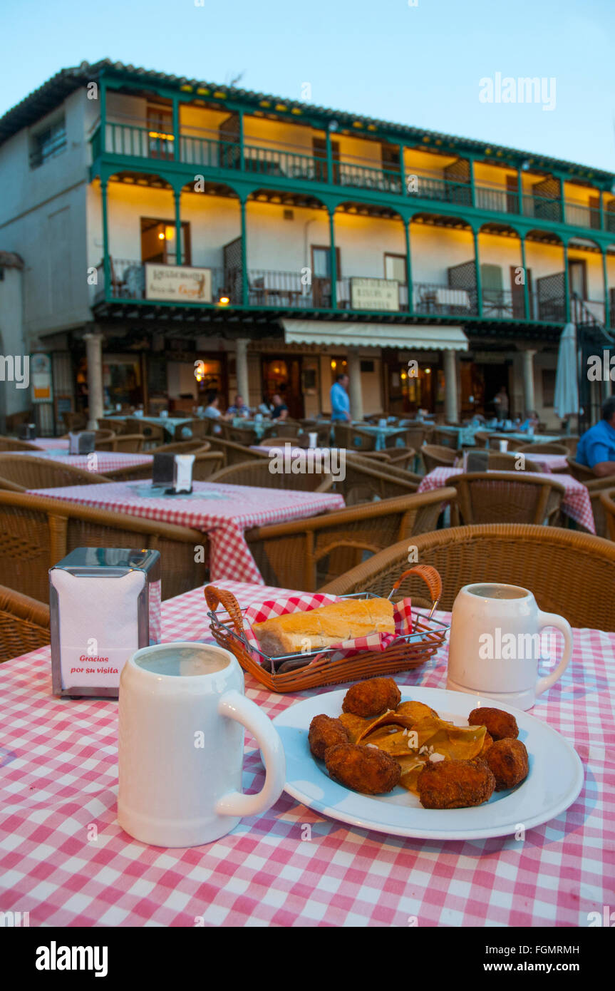 L'Espagnol tapa : croquettes servant et deux pichets de bière blonde dans une terrasse. Place principale, Chinchon, province de Madrid, Espagne. Banque D'Images