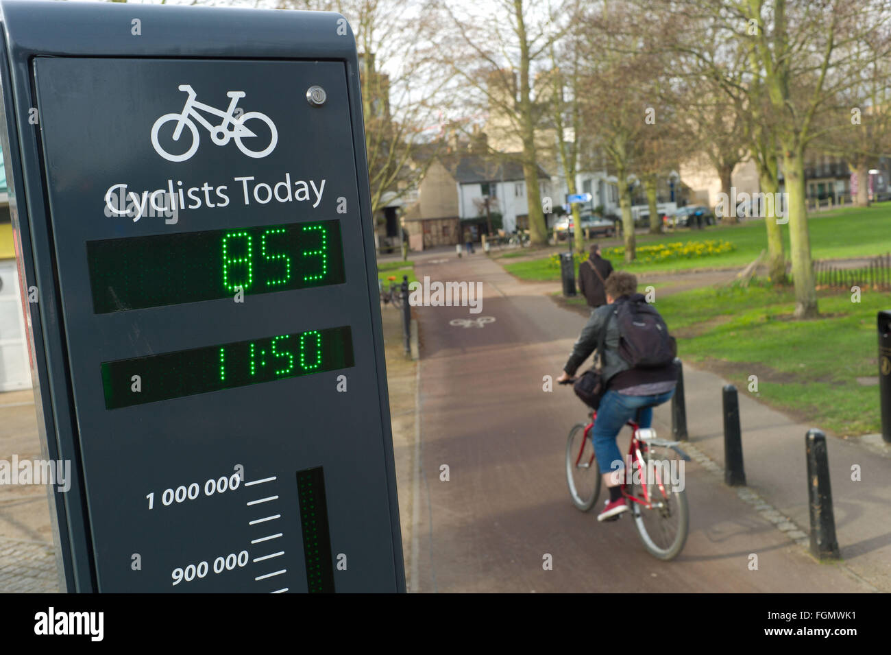 Cycliste passant un signe à Cambridge UK qui montre le nombre de cyclistes qui ont utilisé la piste cyclable ce jour Banque D'Images