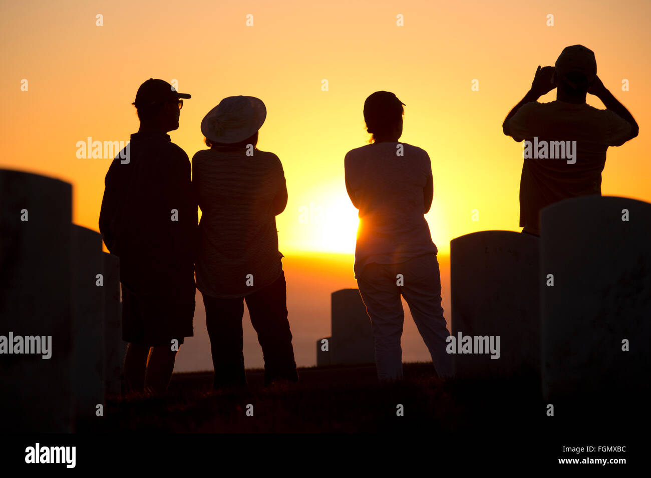 Personnes regardant le coucher du soleil, le cimetière national de Fort Rosecrans, Point Loma, en Californie Banque D'Images