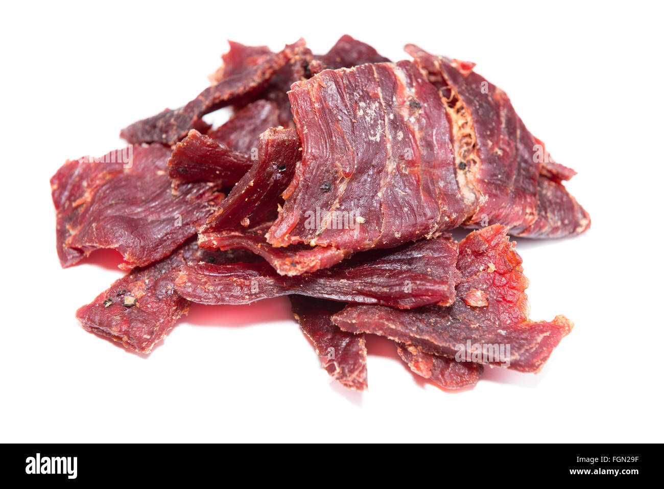 Partie de Beef Jerky (close-up shot) sur fond blanc, pur Banque D'Images