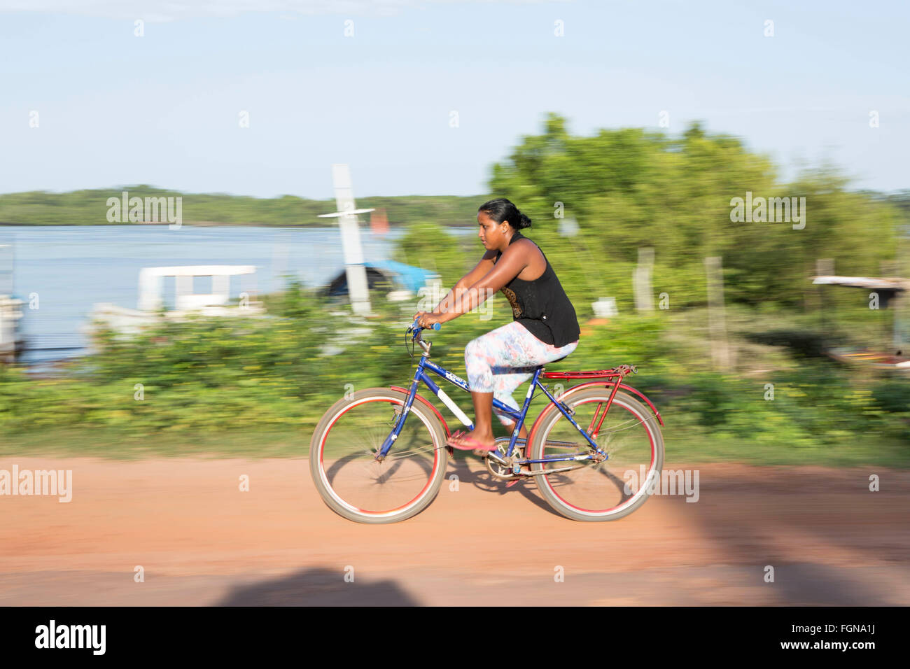 Excès de cycliste passé sur un chemin de terre sur l'île de Marajo [Ilha do Marajo] dans l'Amazonie brésilienne Banque D'Images