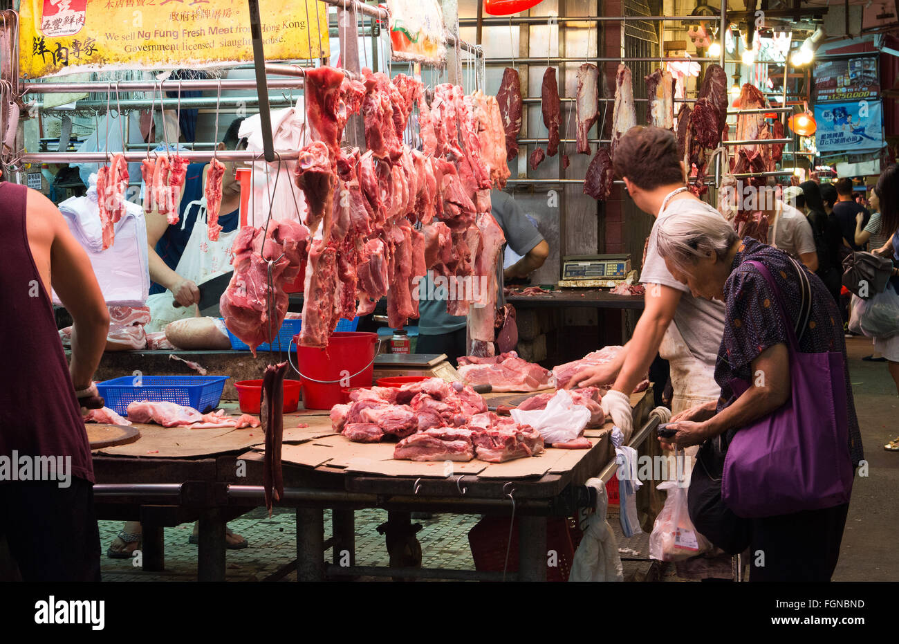Chine Hong Kong Kowloon rue Marché aux poissons, sur la rue de Hoi An Pak avec femme couper du poisson la nuit en petit marché plein air Banque D'Images