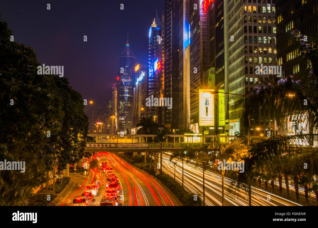 Hong Kong Chine centre-ville de Gloucester Road en trafic crépuscule du soir avec des voitures filant sur route avec des gratte-ciel sur côtés de C Banque D'Images