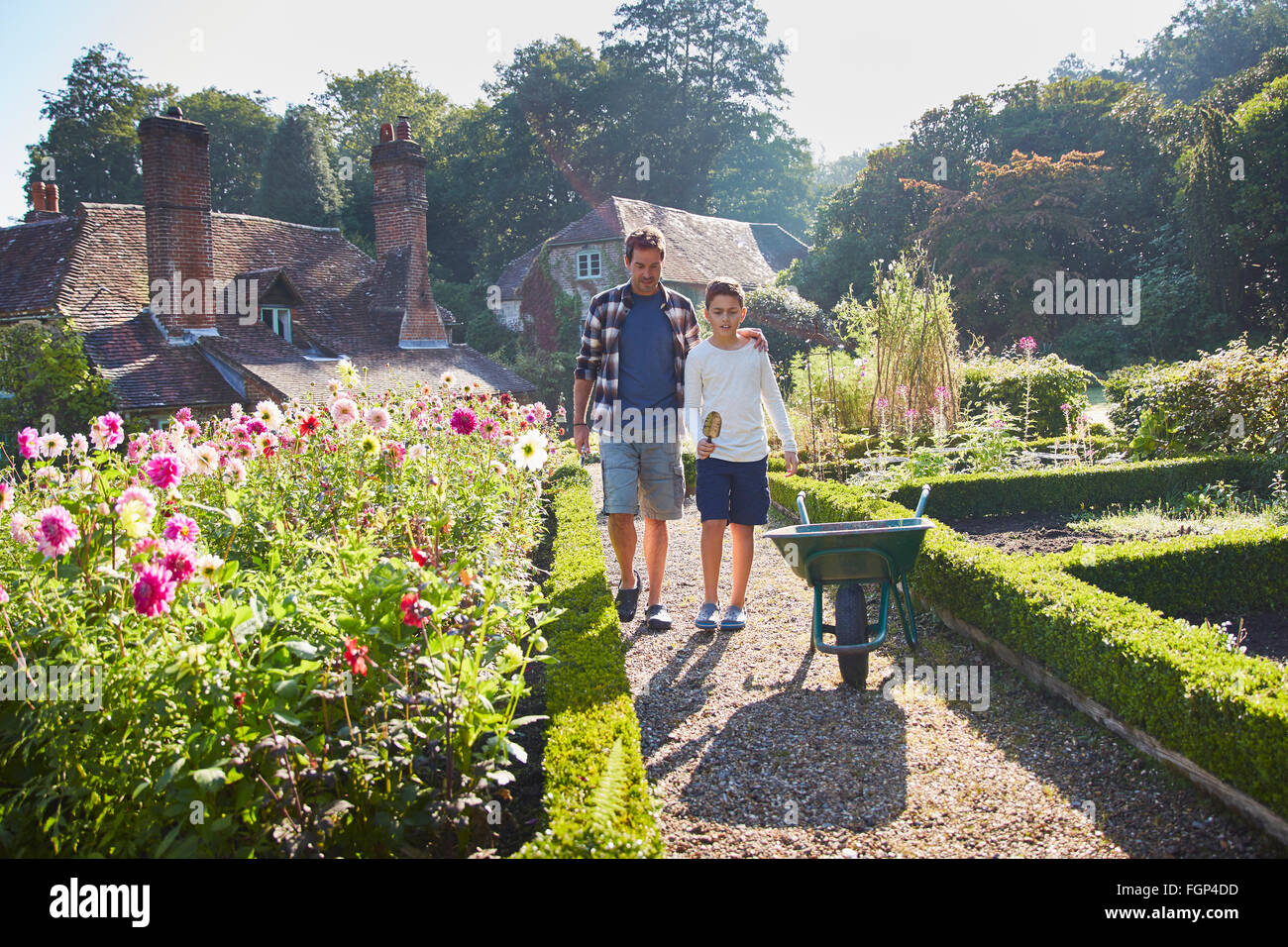 Le père et le fils marchant dans le jardin ensoleillé Banque D'Images