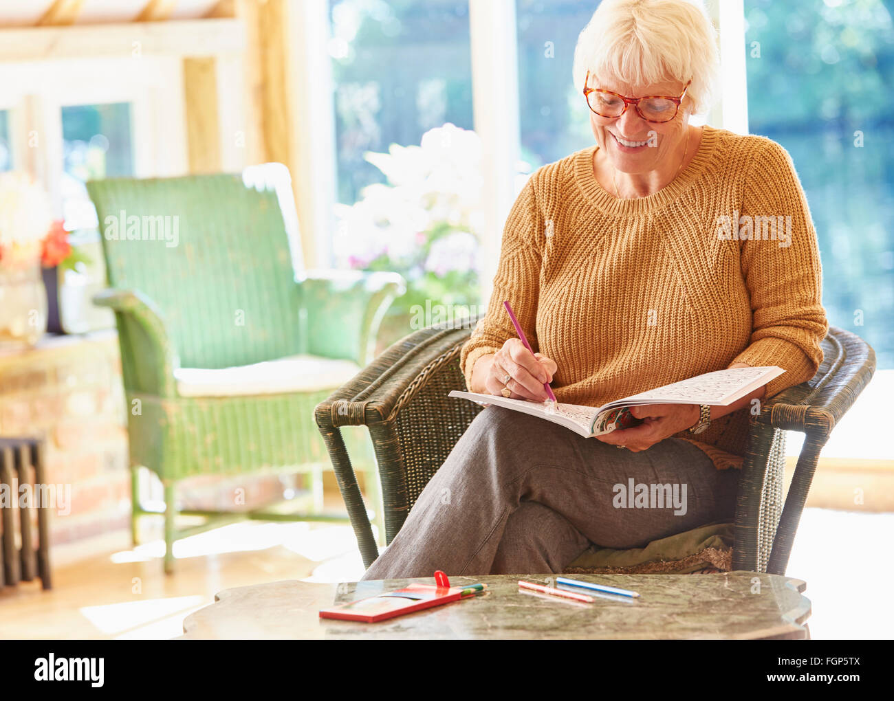 Femme senior dans un livre à colorier coloriage Banque D'Images