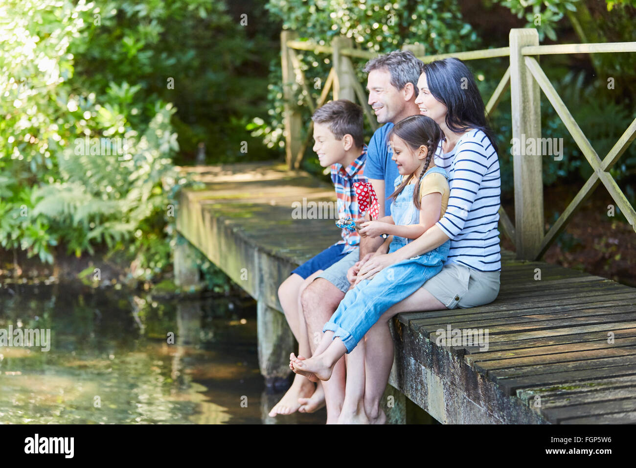 Family sitting au bord de quai Banque D'Images