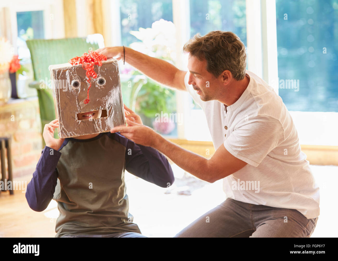 Masque robot Père plaçant sur fils Banque D'Images