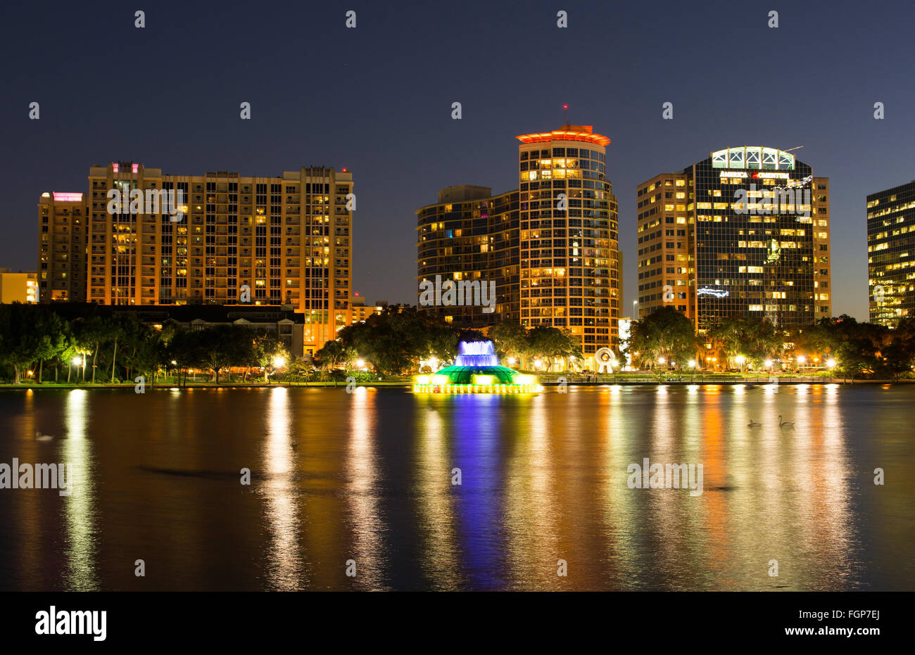 Orlando Floride Lac Eola skyline nuit crépuscule des lumières colorées statue nuit exposition avec skyline gratte-ciel sur l'eau au lac Banque D'Images